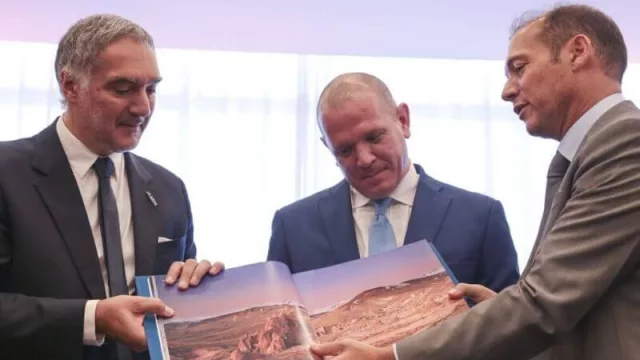 Omar Pirrello, socio gerente de ASPA (izq.) y Francisco González, gerente general de Hilton Garden Inn Neuquén (centro), reciben del gobernador Omar Gutiérrez (der.) el libro de la provincia del Neuquén.